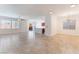 Open-concept living area with tile flooring, large windows, and kitchen at 4740 Killington St, Las Vegas, NV 89129