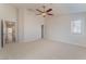 Spacious main bedroom with neutral carpet, ceiling fan, and an ensuite bathroom at 4740 Killington St, Las Vegas, NV 89129