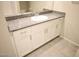 Bathroom featuring a granite countertop, white cabinetry, chrome hardware, and tile flooring at 5269 Acadia Leaf St, Las Vegas, NV 89166
