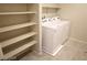 Convenient laundry room featuring washer, dryer, ample shelving and tile floors at 5269 Acadia Leaf St, Las Vegas, NV 89166