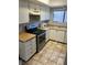 Compact kitchen features stainless steel appliances, light countertops, and tiled flooring at 579 Roxella Ln # D, Las Vegas, NV 89110