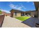 Spacious backyard features artificial turf, rock landscaping, hardscape patio with barbecue and outdoor seating at 6801 Steel Mist St, Las Vegas, NV 89148