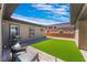 Charming backyard with artificial turf, patio area, seating, and barbecue, perfect for outdoor entertaining and relaxation at 6801 Steel Mist St, Las Vegas, NV 89148