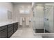 Modern bathroom featuring dual sink vanity, marble counters, large walk-in shower with sleek gray tile at 6801 Steel Mist St, Las Vegas, NV 89148