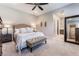 Comfortable bedroom with neutral tones, carpet, ceiling fan, ensuite bathroom and walk-in closet access at 6801 Steel Mist St, Las Vegas, NV 89148