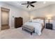 Comfortable carpeted bedroom with a ceiling fan, a tufted headboard bed and natural light at 6801 Steel Mist St, Las Vegas, NV 89148