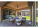 Inviting covered patio features stylish outdoor seating, ceiling fan, and a serene view of the well-maintained backyard at 6801 Steel Mist St, Las Vegas, NV 89148