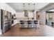 Gourmet kitchen with stainless steel appliances, white cabinets, island seating and hardwood floors at 6801 Steel Mist St, Las Vegas, NV 89148