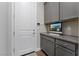 Mudroom with gray cabinets, countertop workspace, and adjacent door providing convenient storage and organization at 6801 Steel Mist St, Las Vegas, NV 89148