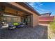 Relaxing covered patio area with comfortable seating, ceiling fan, and a view of the manicured backyard at 6801 Steel Mist St, Las Vegas, NV 89148