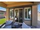 Covered brick patio with an outdoor seating area as seen from the interior of the home through sliding glass doors at 6801 Steel Mist St, Las Vegas, NV 89148
