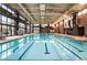 Well-lit indoor swimming pool with lap lanes, surrounded by large windows and comfortable seating at 6801 Steel Mist St, Las Vegas, NV 89148