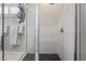 Modern walk-in shower featuring sleek white tile, a dark tiled floor and glass door at 6801 Steel Mist St, Las Vegas, NV 89148