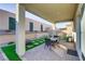 Cozy backyard featuring a covered patio, outdoor seating, and artificial grass at 8729 Marcana St, Las Vegas, NV 89166