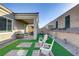 Private backyard featuring a covered patio, artificial grass, and a unique decorative wall at 8729 Marcana St, Las Vegas, NV 89166