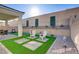 Relaxing backyard with artificial turf, decorative rocks, a covered patio, and decorative statues at 8729 Marcana St, Las Vegas, NV 89166