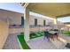 Backyard featuring a covered patio, outdoor seating, and artificial grass at 8729 Marcana St, Las Vegas, NV 89166