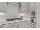 Kitchen showing stainless steel appliances, modern countertops, range hood, and built in microwave and oven at 8729 Marcana St, Las Vegas, NV 89166