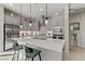 Bright kitchen features stainless steel appliances, pendant lighting, modern gray cabinetry, and a large center island with seating at 8729 Marcana St, Las Vegas, NV 89166