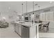 This open-concept kitchen features an island with seating and sink, which seamlessly connects to dining and living areas at 8729 Marcana St, Las Vegas, NV 89166