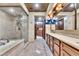 Expansive bathroom featuring a glass shower, soaking tub, dual vanities, and mounted TVs, perfect for relaxation at 9103 Alta Dr # 1502, Las Vegas, NV 89145
