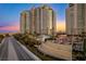 High-rise building with lush landscaping, water features, and grand entrance, set against a stunning sunset at 9103 Alta Dr # 1502, Las Vegas, NV 89145