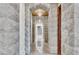 Elegant hallway features stone walls, marble floors, and crystal chandeliers, creating a luxurious and sophisticated entrance at 9103 Alta Dr # 1502, Las Vegas, NV 89145