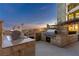 An outdoor kitchen is equipped with built-in stainless steel grills, a sink, and stone countertops at 9103 Alta Dr # 1502, Las Vegas, NV 89145