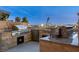An outdoor kitchen features built-in stainless steel grills, a mini-fridge, and stone countertops at 9103 Alta Dr # 1502, Las Vegas, NV 89145
