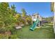 Charming backyard play area with playhouse, slide, and manicured artificial turf at 9765 Skye Star Ave, Las Vegas, NV 89166