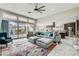 Spacious living room featuring a large sofa, tile floors, a ceiling fan, and a sliding glass door to the backyard at 9765 Skye Star Ave, Las Vegas, NV 89166