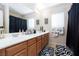 Spacious bathroom features double sinks, vanity, decorative rugs and black shower curtain at 10608 Medicine Bow St, Las Vegas, NV 89183