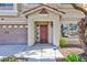 Inviting front entrance featuring a charming porch and a welcoming red door, complemented by a two-car garage at 10608 Medicine Bow St, Las Vegas, NV 89183