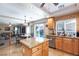 Bright kitchen with tan countertops, tile flooring, an island, and a window offering views of the outdoor pool at 10608 Medicine Bow St, Las Vegas, NV 89183