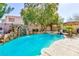 Resort-style pool area with lush greenery, rock features, and a relaxing ambiance at 10608 Medicine Bow St, Las Vegas, NV 89183
