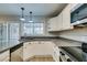 Bright kitchen with stainless steel appliances, dark countertops and white cabinetry, and sliding glass doors to the backyard at 2506 Paradise Village Way, Las Vegas, NV 89120