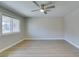 Spacious living room with one window, sleek light-colored hardwood flooring, and contemporary ceiling fan at 2506 Paradise Village Way, Las Vegas, NV 89120