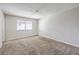 An empty bedroom featuring neutral carpet and white walls basks in natural light from a window with blinds at 3337 Irv Marcus Dr, Las Vegas, NV 89108