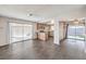 Open living area with wood floors, sliding door to backyard, and adjacent kitchen at 3337 Irv Marcus Dr, Las Vegas, NV 89108