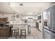 Bright kitchen with stainless steel refrigerator, granite countertops, kitchen island, and open floor plan at 378 Colleen Ct # G, Mesquite, NV 89027