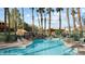 Relaxing community pool area featuring a waterfall, palm trees, and lounge chairs at 378 Colleen Ct # G, Mesquite, NV 89027