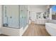 Modern main bathroom with a glass shower, soaking tub, dual vanity sinks, and hardwood floors at 379 Portus Delphini Ct, Henderson, NV 89011