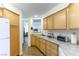 Well-lit kitchen featuring wood cabinets, light countertops, and modern appliances at 5155 W Tropicana Ave # 1173, Las Vegas, NV 89103