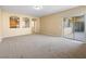Neutral living room with sliding glass door, carpeting, and views to kitchen and hallways at 6360 Bullring Ln, Las Vegas, NV 89130