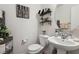 Cozy half bathroom featuring a stylish sink, toilet, decorative shelving, and modern decor at 6527 Netherseal Ave, Las Vegas, NV 89139