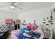 Bright bedroom with white walls, ceiling fan, and eclectic decor at 6527 Netherseal Ave, Las Vegas, NV 89139