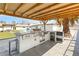 Outdoor kitchen under a pergola with a built-in grill, countertop, and ample space for entertaining at 7440 Edna Ave, Las Vegas, NV 89117