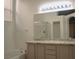 Bright bathroom with a large mirror, granite countertops, a bathtub, and a separate glass-enclosed shower at 7515 Splashing Rock Dr, Las Vegas, NV 89131