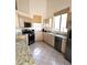 Bright kitchen with modern stainless-steel appliances, granite countertops, and tile flooring at 7515 Splashing Rock Dr, Las Vegas, NV 89131