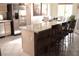 Kitchen island with seating, tile floors, and a view of the dining area and stainless steel refrigerator at 7515 Splashing Rock Dr, Las Vegas, NV 89131